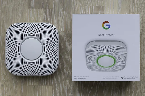 Bild på Google Nest Protect wifi brandvarnare sida vid sida med sin förpackning